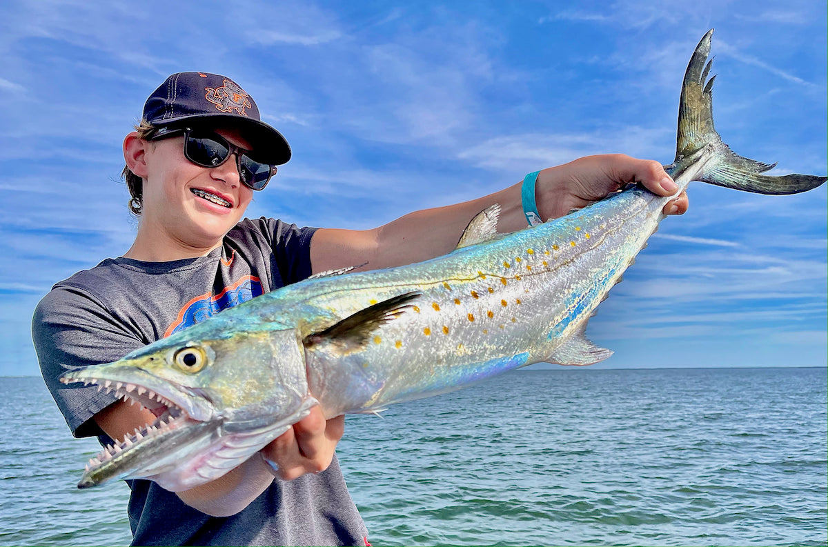 Kid Fishing Charter Holding Up Fish